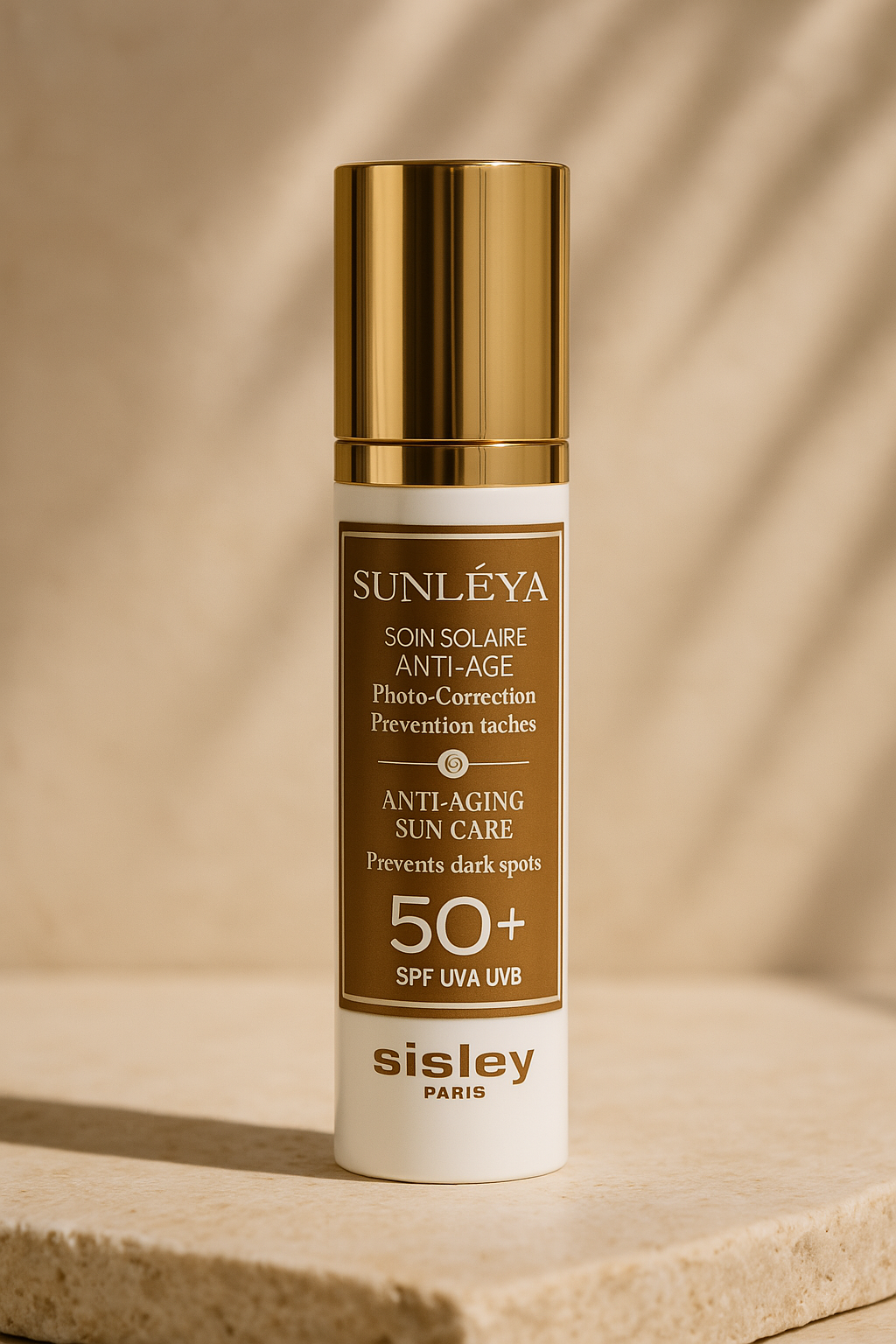 Elegant bottle of Sisley Paris Sunleÿa Anti-Aging Sun Care with gold cap, featuring SPF 50+ and claims of dark spot prevention and photo-correction, photographed against a soft, neutral background.